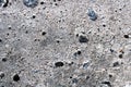 Grungy grey concrete wall background with stones