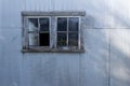 Grungy old window on a corrugated metal shed wall Royalty Free Stock Photo