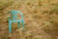 Grungy Retro Damaged Plastic Green Chair Abandoned in a Field