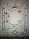 Rusty steel hatch door secured with nuts and bolts