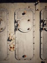 Rusty steel hatch door secured with nuts and bolts