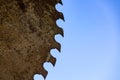 Grungy saw wheel against blue sky