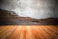 Grungy textured red brick and stone wall with warm brown wooden floor inside old neglected and deserted interior, masonry and carp Royalty Free Stock Photo