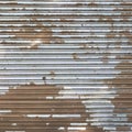 Grungy industrial brown metal door with peeling white paint