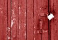 Grungy wooden door with lock in red tone Royalty Free Stock Photo