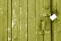 Grungy wooden door with lock in yellow tone Royalty Free Stock Photo