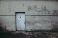 Grungy worn out metallic door in the wall of an old prison of the communist Romanian Securitate