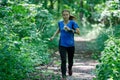 GRUNIVKA, SUMY REGION, UKRAINE - JUNE 21, 2021: Sportswoman running through the forest on the race of SKIF Cup XIV