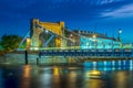 Grunwaldzki suspension bridge in Wroclaw, Poland at dusk with fast moving cars, trams creating traffic light trails