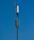 A GSM antenna on a sky blue background Royalty Free Stock Photo