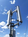 GSM base station antenna in front of blue cloudy sky Royalty Free Stock Photo