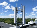 GSM base station antenna in front of blue cloudy sky Royalty Free Stock Photo