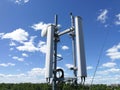 GSM base station antenna in front of blue cloudy sky Royalty Free Stock Photo