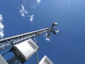 GSM base station antenna in front of blue cloudy sky Royalty Free Stock Photo