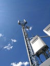 GSM base station antenna in front of blue cloudy sky Royalty Free Stock Photo