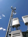 GSM base station antenna in front of blue cloudy sky Royalty Free Stock Photo