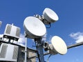 GSM base station antenna in front of blue cloudy sky Royalty Free Stock Photo