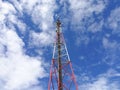 GSM repeater tower in front of blue cloudy sky Royalty Free Stock Photo