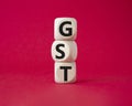 GST - Goods and Services Tax symbol. Concept word GST on wooden cubes. Beautiful red background. Business and GST concept. Copy Royalty Free Stock Photo