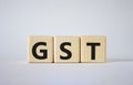 GST - Goods and Services Tax symbol. Concept word GST on wooden cubes. Beautiful white background. Business and GST concept. Copy Royalty Free Stock Photo