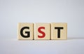 GST - Goods and Services Tax symbol. Concept word GST on wooden cubes. Beautiful white background. Business and GST concept. Copy Royalty Free Stock Photo