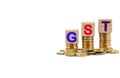 GST or TAX Concept with colorful wooden block and stacked coins Royalty Free Stock Photo