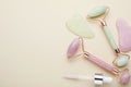 Gua sha tools, facial rollers and dropper on beige background, flat lay. Space for text