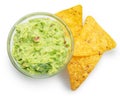 Guacamole bowl and corn chips near it on white background. Top view. File contains clipping path