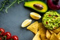 Guacamole bowl with ingredients and tortilla chips on a stone table. Top view image. Copyspace for your text. Royalty Free Stock Photo