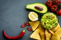 Guacamole bowl with ingredients and tortilla chips on a stone table. Top view image. Copyspace for your text. Royalty Free Stock Photo