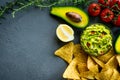 Guacamole bowl with ingredients and tortilla chips on a stone table. Top view image. Copyspace for your text. Royalty Free Stock Photo