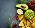 Guacamole bowl with ingredients and tortilla chips on a stone table. Top view image. Copyspace for your text. Royalty Free Stock Photo