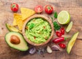 Guacamole, guacamole ingredients and chips on wooden background. Flat lay