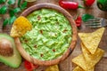 Guacamole, guacamole ingredients and chips on wooden background. Flat lay