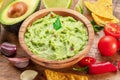 Guacamole, guacamole ingredients and chips on wooden background Royalty Free Stock Photo
