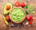 Guacamole, guacamole ingredients and chips on wooden background. Flat lay