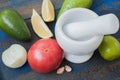 Guacamole - latin american sauce and ingredients avocado, tomatoes, onion, lemon, garlic, lime on blue wooden background. Royalty Free Stock Photo