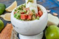 Guacamole - latin american sauce and ingredients avocado, tomatoes, onion, lemon, garlic, lime on blue wooden background. Royalty Free Stock Photo