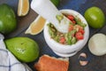 Guacamole - latin american sauce and ingredients avocado, tomatoes, onion, lemon, garlic, lime on blue wooden background. Royalty Free Stock Photo