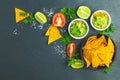 Guacamole and nachos with ingredients on the background of a black stone board Royalty Free Stock Photo