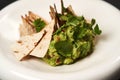 Guacamole with pita chips on white plate. Chef`s signature dish Royalty Free Stock Photo