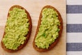 Guacamole sandwich on light background. avocado sandwiches on wooden board and textile top view