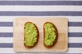 guacamole sandwich on light background. avocado sandwiches on wooden board and textile top view