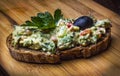 Guacamole sandwich on a wooden background decorated with olives and parsley