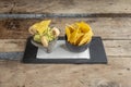 Guacamole with tortilla chips and torreznos on traditional Mexican volcanic Royalty Free Stock Photo