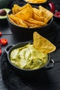 Guacamole traditional mexican spicy avocado dip, on black wooden background