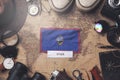 Guam Flag Between Traveler`s Accessories on Old Vintage Map. Overhead Shot