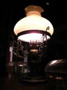 An elegant old-fashioned brass lamp gently shining from the dark corner near my table in the restaurant