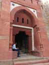 Guard sitting at the gate of Mausoleum of Ghiyath al-Din Tughluq