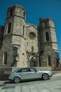 Car at the gothic facade with steeples at the Guarda Cathedral
